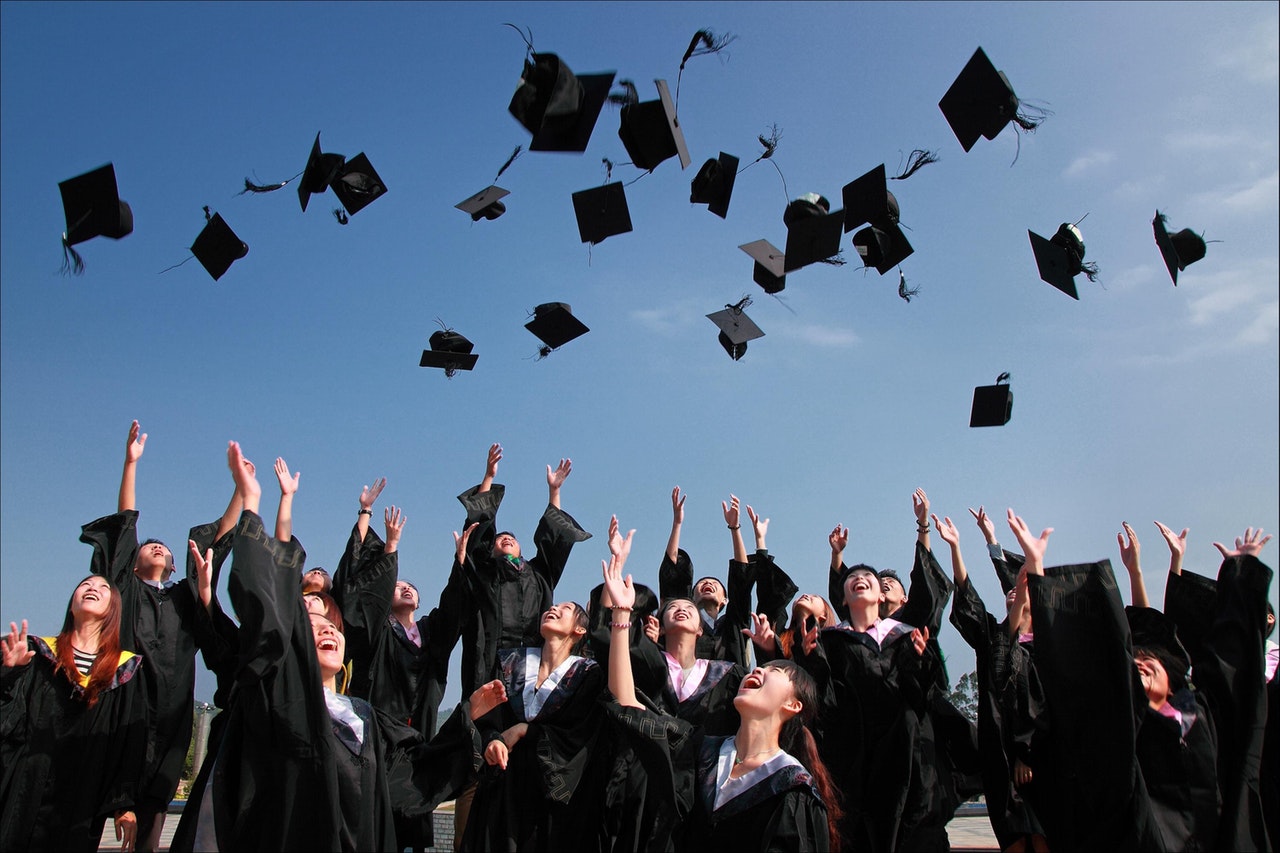 graduates tossing graduation caps