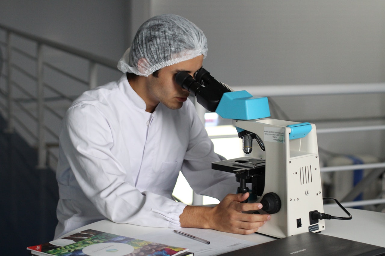 an adult using a microscope